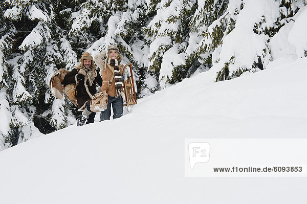 Österreich  Salzburger Land  Paar Wanderungen durch die Winterlandschaft  lächelnd