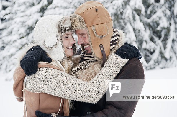 Österreich  Salzburger Land  Paar umarmt sich  lächelnd