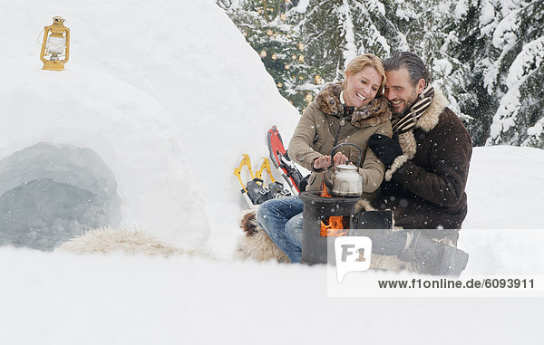 Austria  Salzburg County  Couple sitting near fireplace  smiling