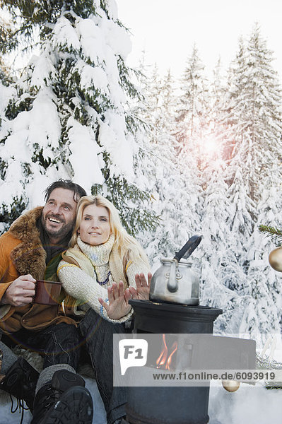 Österreich  Salzburger Land  Paar beim Campingkocher sitzend und Tee trinkend