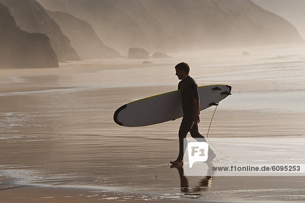Portugal  Surfer walking on beach