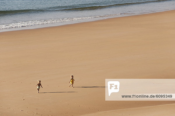 Portugal  Junge und Mädchen rennen am Strand