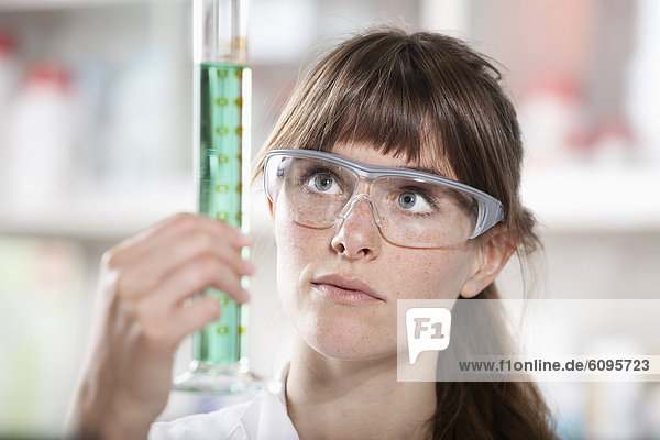 Deutschland  Bayern  München  Wissenschaftler mit Reagenzglas im Labor