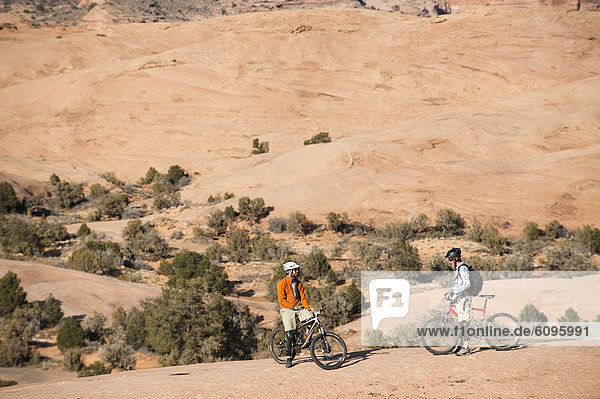 Two mountain bikers rests during a ride on the Slickrock Trail  Moab  UT.