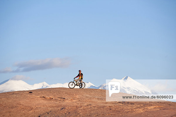 A mountain biker rests during a ride on the Slickrock Trail  Moab  UT.