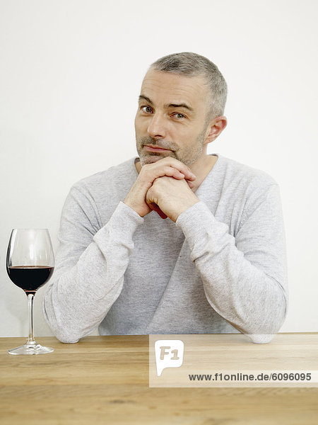 Mature man with wine in kitchen  portrait