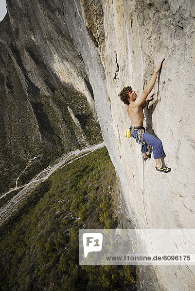 A rock climber ascends a steep rock face in Mexico.