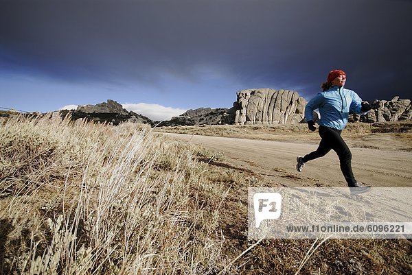 A woman running along a dirt road.