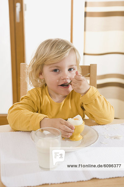 Mädchen essen gekochtes Ei im Frühstück  essen Ei