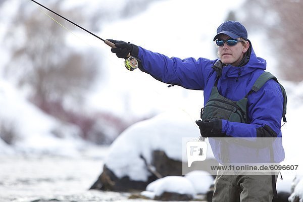 A man winter fishing in Provo River  Utah.