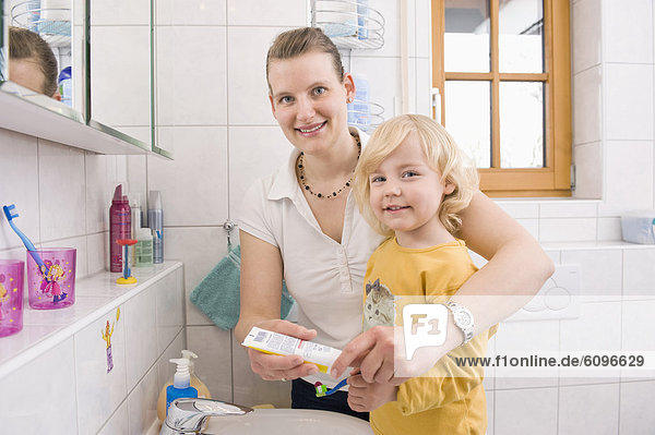 Mutter helfende Tochter zum Zähneputzen  lächelnd  Portrait