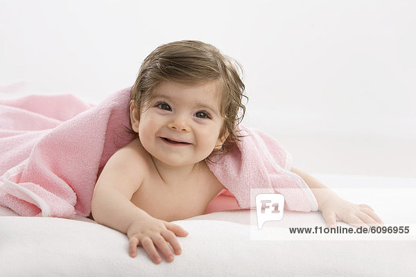 Baby Mädchen mit rosa Decke  lächelnd