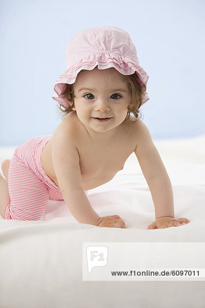 Kleines Mädchen auf Decke kriechend  lächelnd
