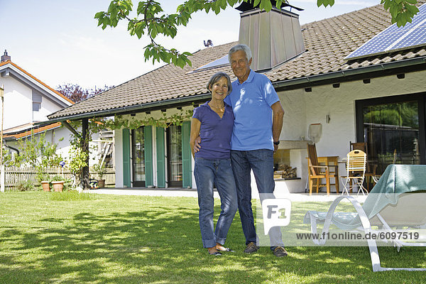 Germany  Bavaria  Senior couple standing in yard  smiling