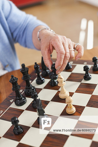Senior woman playing chess game