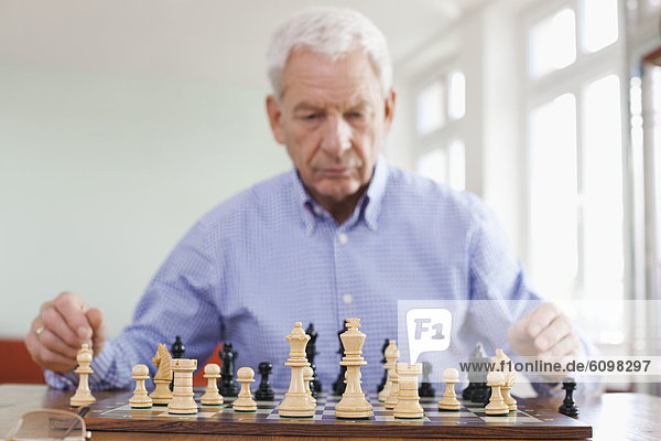 Senior man playing chess game