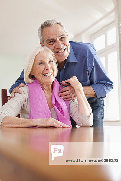 Senior man and woman sitting at table  smiling