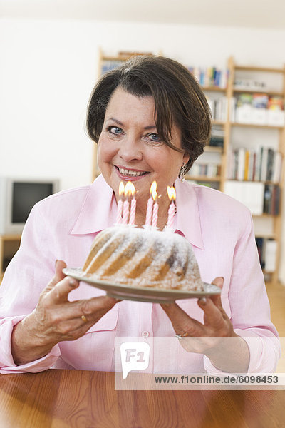 Senior woman holding birthday cake