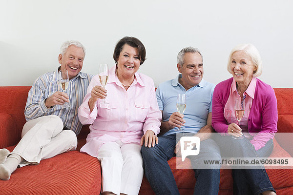 Senior men and women drinking sparkling wine  smiling