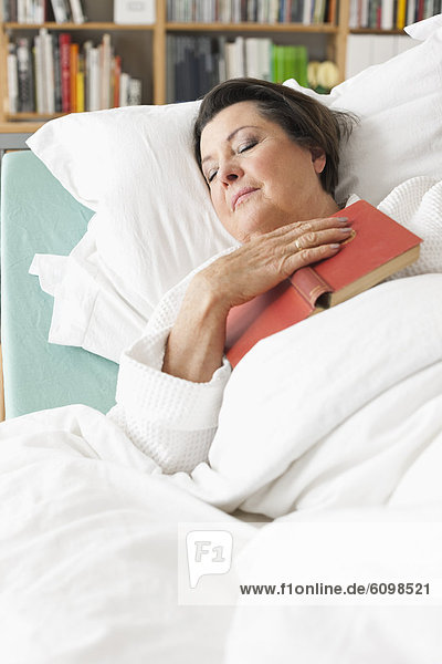 Seniorin entspannt auf dem Krankenbett