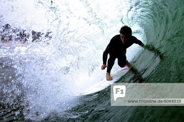 An advanced male surfer rides the tube.