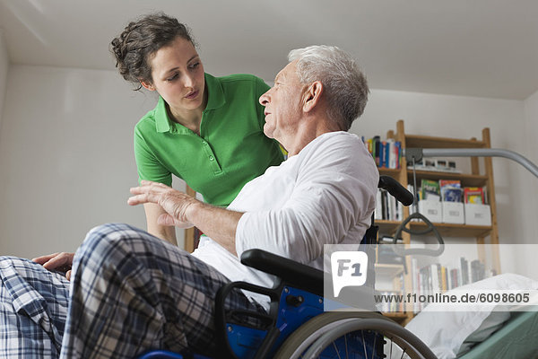 Mann im Rollstuhl  im Gespräch mit Frau