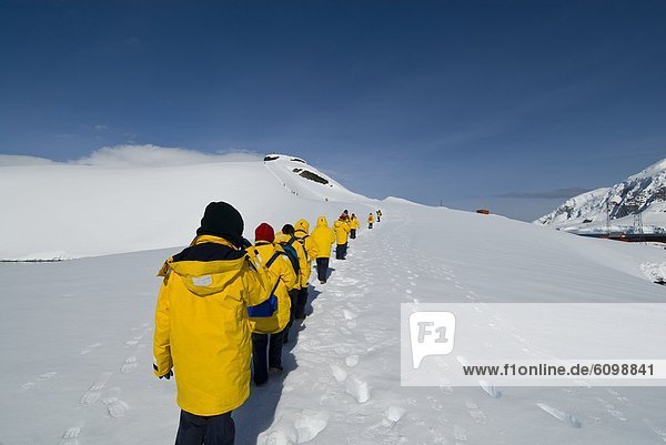 Tourists walking along a snow slope  Antarctica.