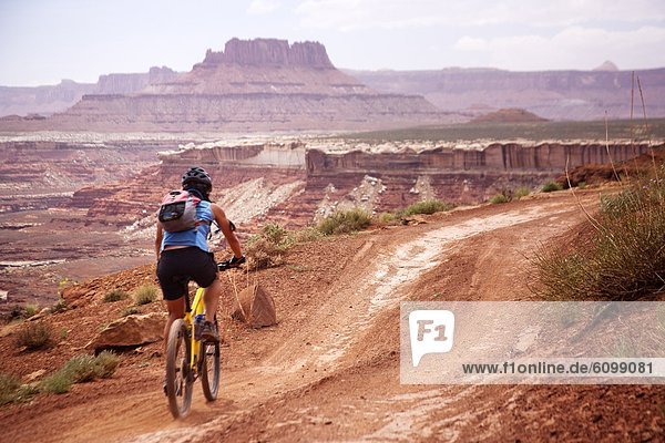 A woman bikes the White Rim trail in Utah.