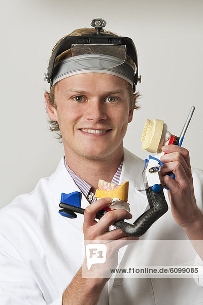 Dentist holding dentures in articulator  portrait
