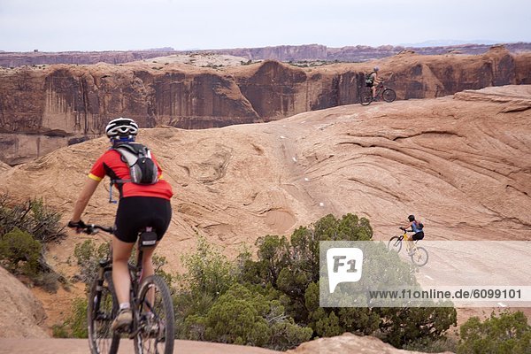A woman mountain bikes one of the Slick Rock routes in Moab Utah.