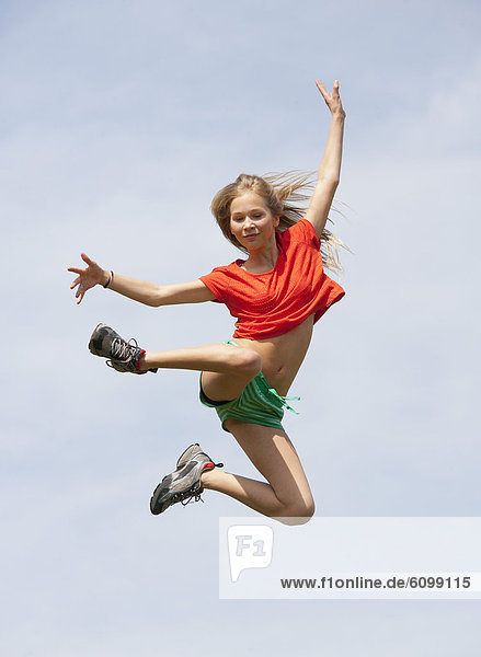 Österreich  Teenager-Mädchen springt gegen den Himmel