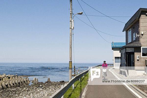 Woman riding a bicycle  Rebun town  Rebun-to Island  Hokkaido  Japan
