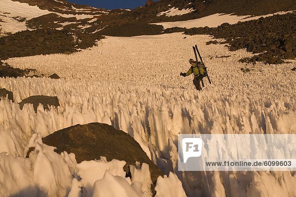 A man skiing through penitentes at sunset on Volcan San Jose in the Andes mountains of Chile