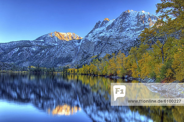 Fall colors and snow capped peaks line Silver Lake in the Eastern Sierra  California.