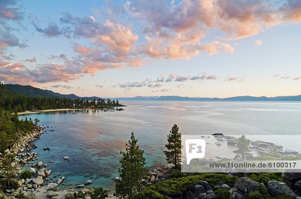 Beautiful clouds are illuminated at sunset over Sand Harbor and Lake Tahoe  Nevada.