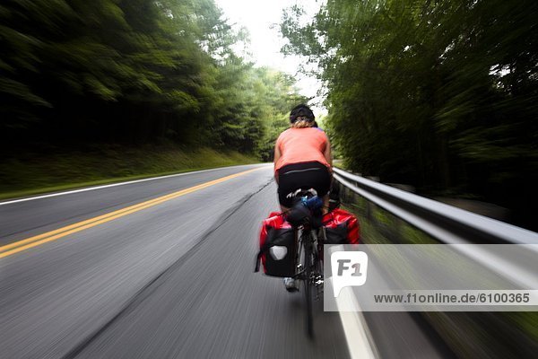 A female and male cyclist quickly pedal down Route 4 near Quechee  Vermont.