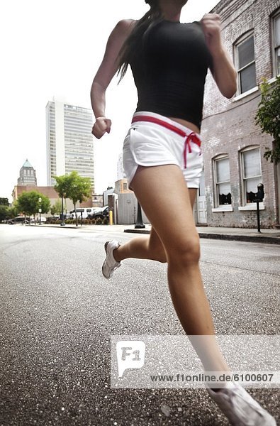 Young woman running on an empty city street in Mobile  Alabama. (motion blur)