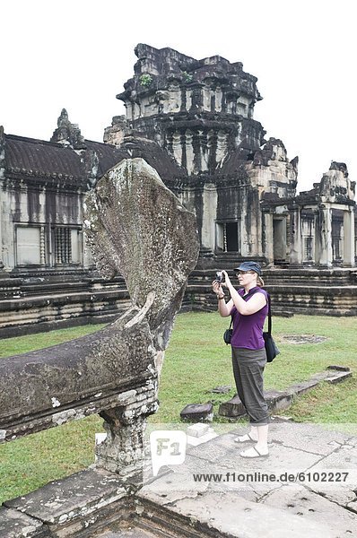 Woman taking a photograph  Angkor Wat  Cambodia.