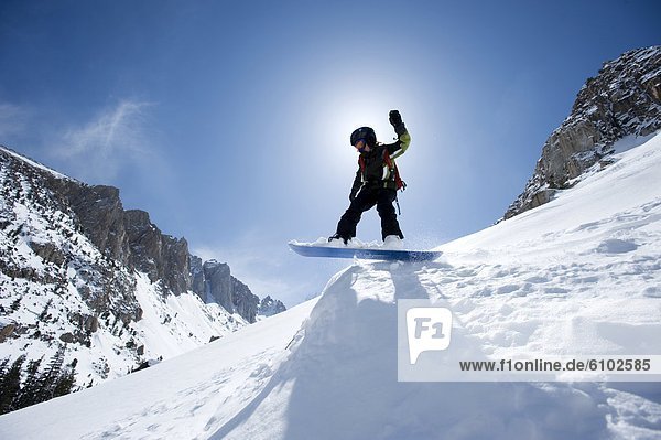 A boy snowboarding in the California backcountry.