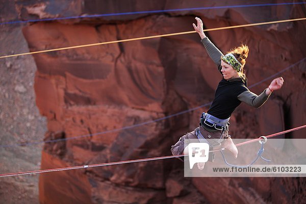 A female highliner poses on a highline at the Fruit Bowl in Moab  Utah  USA.