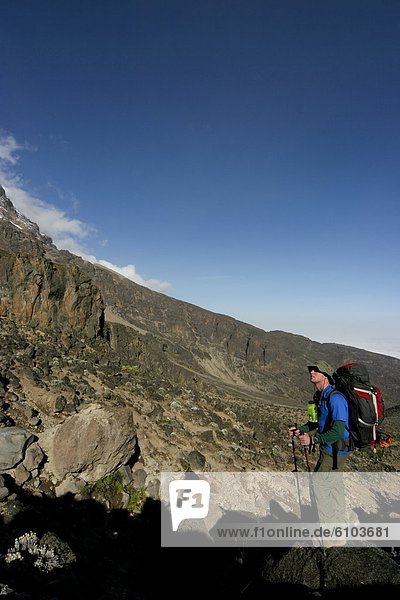 Hiker overlooking Mount Kilimanjaro on the way up to the summit.