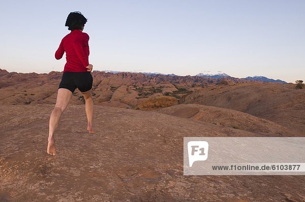 Man barefoot running on sandstone  Moab  Utah.