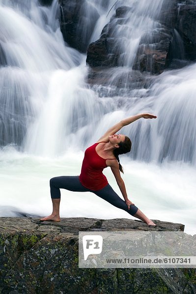 A woman performs yoga in front of a large waterfall in Lake Tahoe  California.