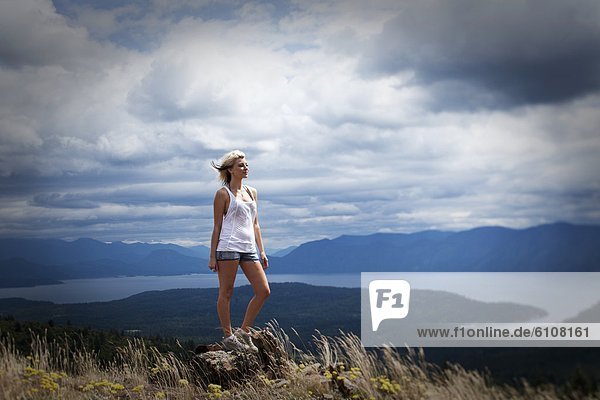 A woman standing on top of a mountain on a stormy day in Idaho.