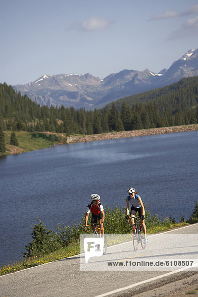 Cyclists riding at the crest of a mountain pass near Vail  Colorado.