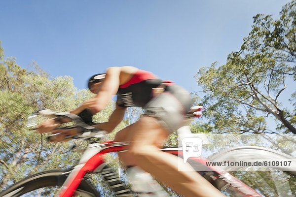 A Triathlete flashes by on a bicycle  Noosa  Queensland  Australia.
