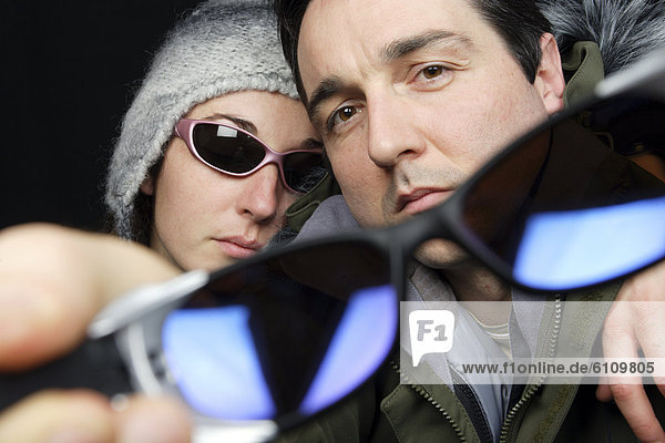 Joyful couple wearing sunglasses.