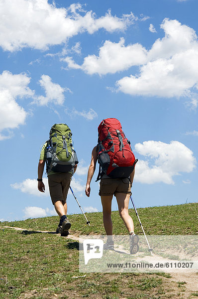 Hikers with backpacks on trail.
