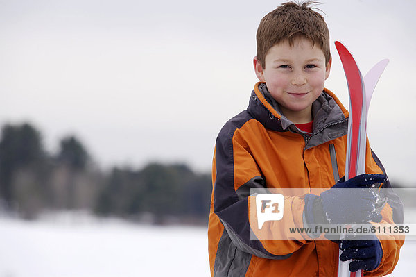 Portrait of young boy with xc skis.