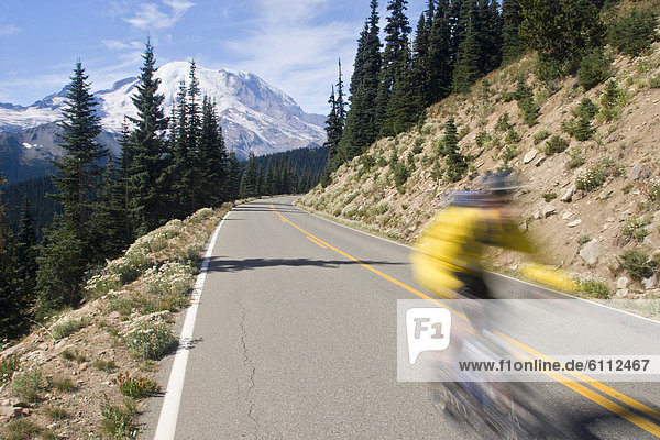 Young man mountain biking on road.